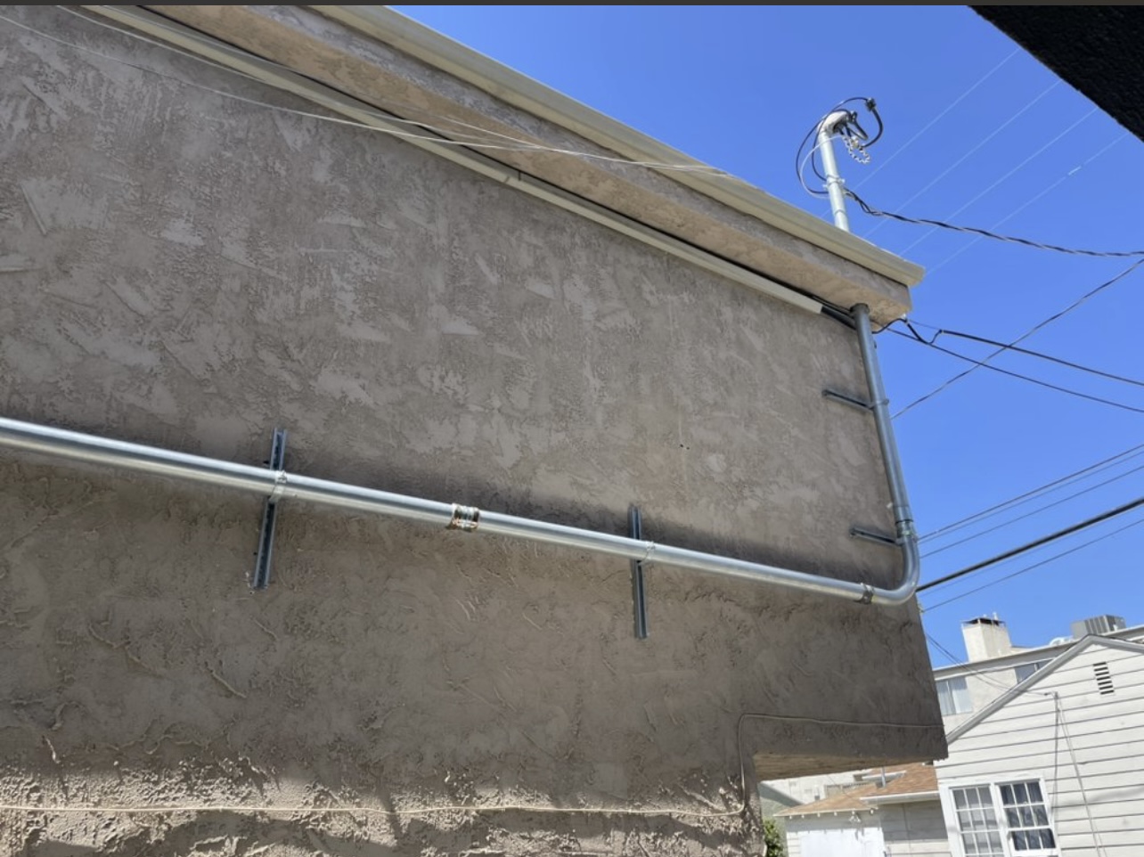 Exterior conduit run across stucco wall